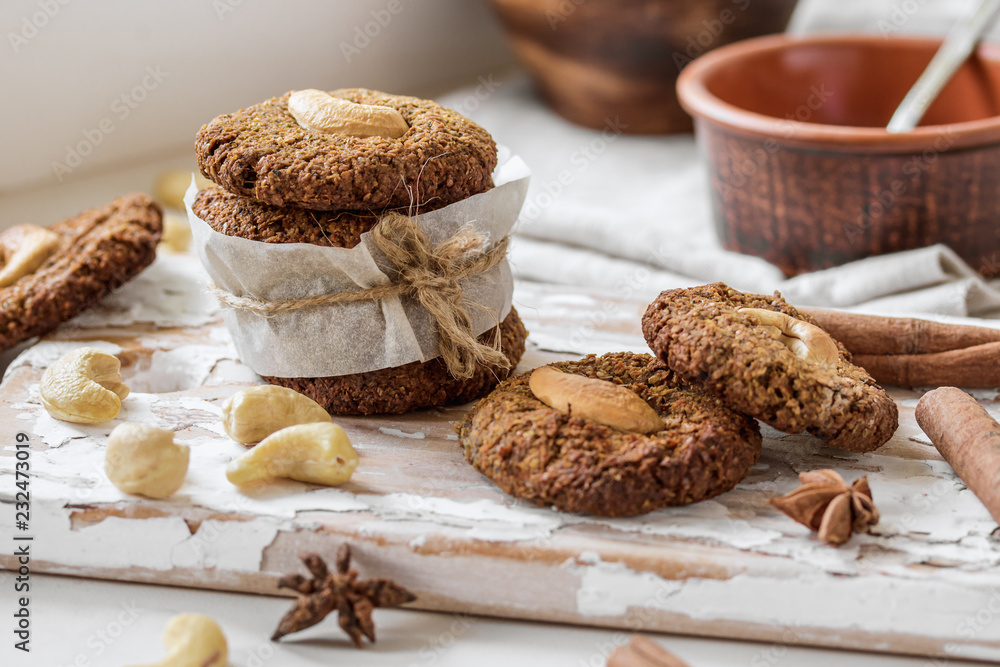 Homemade nutty vegan cinnamon cookies on white beige wooden board, close-up, natural light Homemade nutty vegan cinnamon cookies on white beige wooden board, close-up, natural light