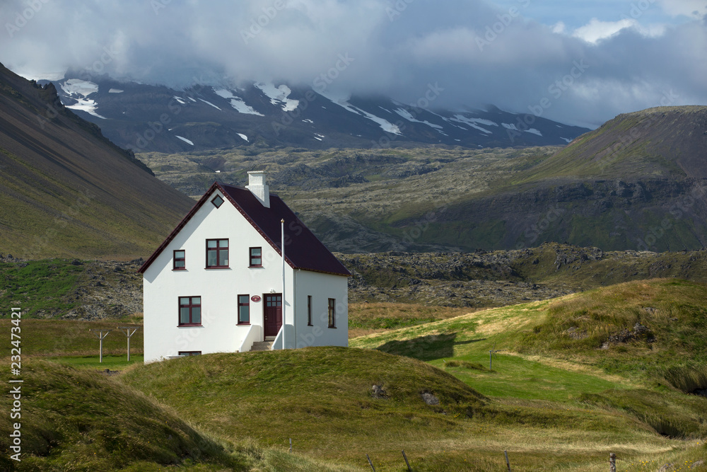 Lonely house at the bottom of mountain, Iceland.