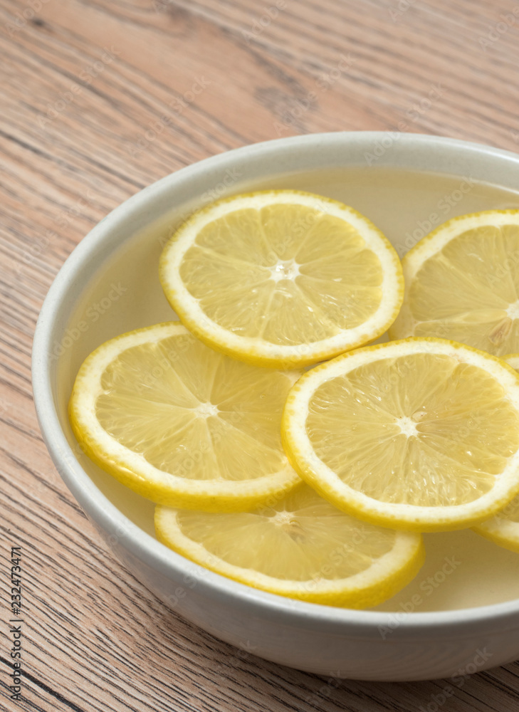 Lemon slices in a bowl with water. Lemon slices in a bowl with water.