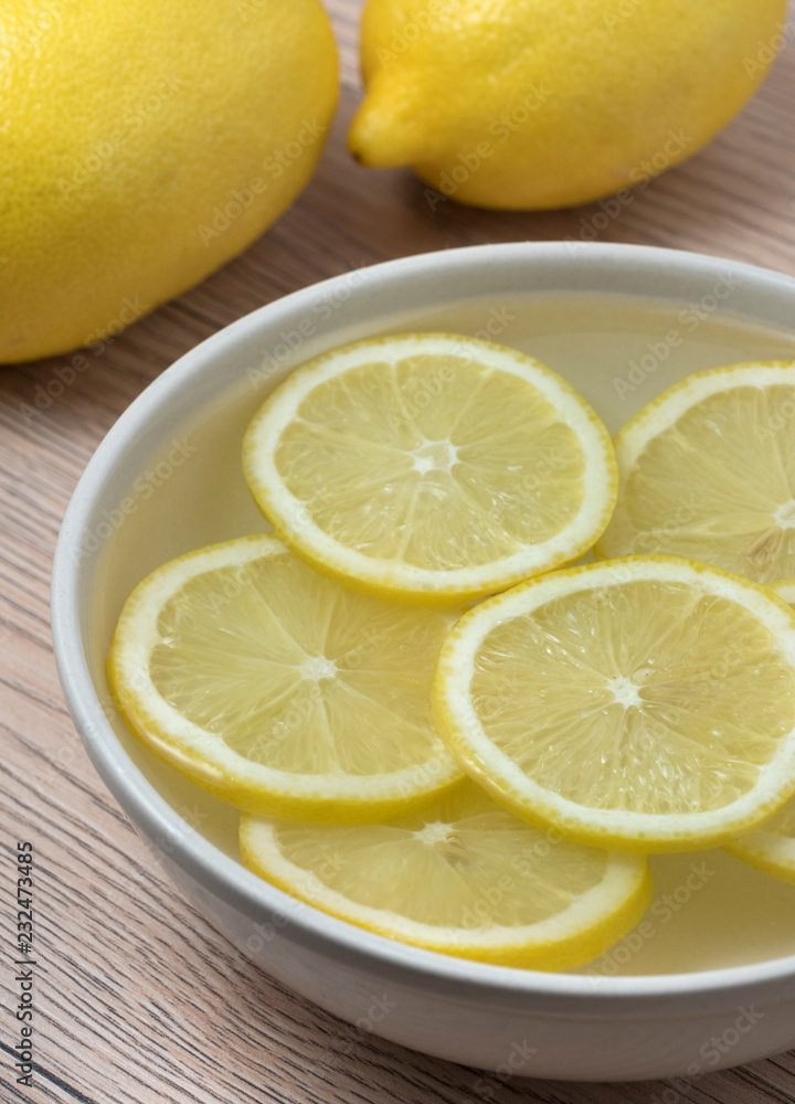Lemon slices in a bowl with water. Lemon slices in a bowl with water.