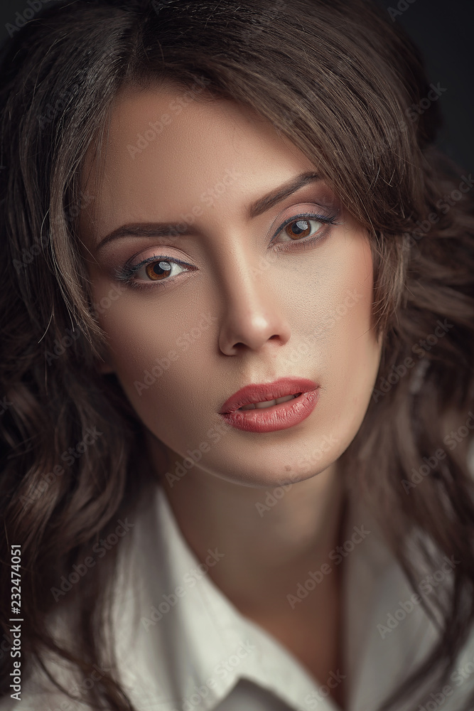 A beautiful young brunette girl looks into the camera. Fashion makeup. A beautiful young brunette girl looks into the camera. Fashion makeup.