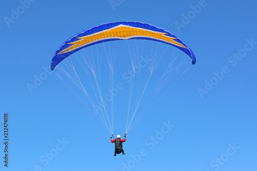 Paraglider flying in a blue sky