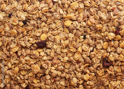 Muesli breakfast background. Organic crunchy homemade granola cereal with oats and berries. Oatmeal granola texture, top view, flat lay.