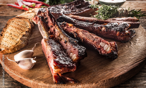 Tasty barbecue grilled pork ribs with chili pepers and parsley herbs. photo