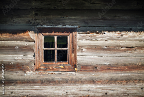 Wooden window in the old textured vintage wood logs wall background.