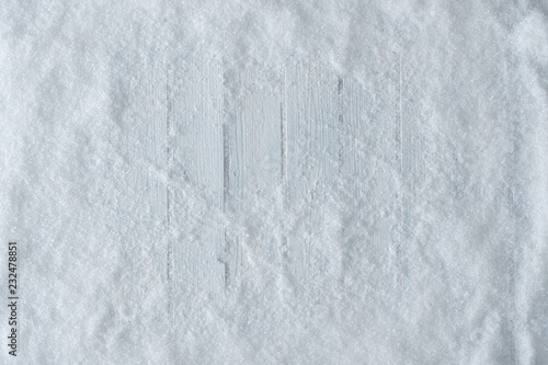 White wooden table background with snow. Winter or Christmas top view. Minimal flat lay. photo