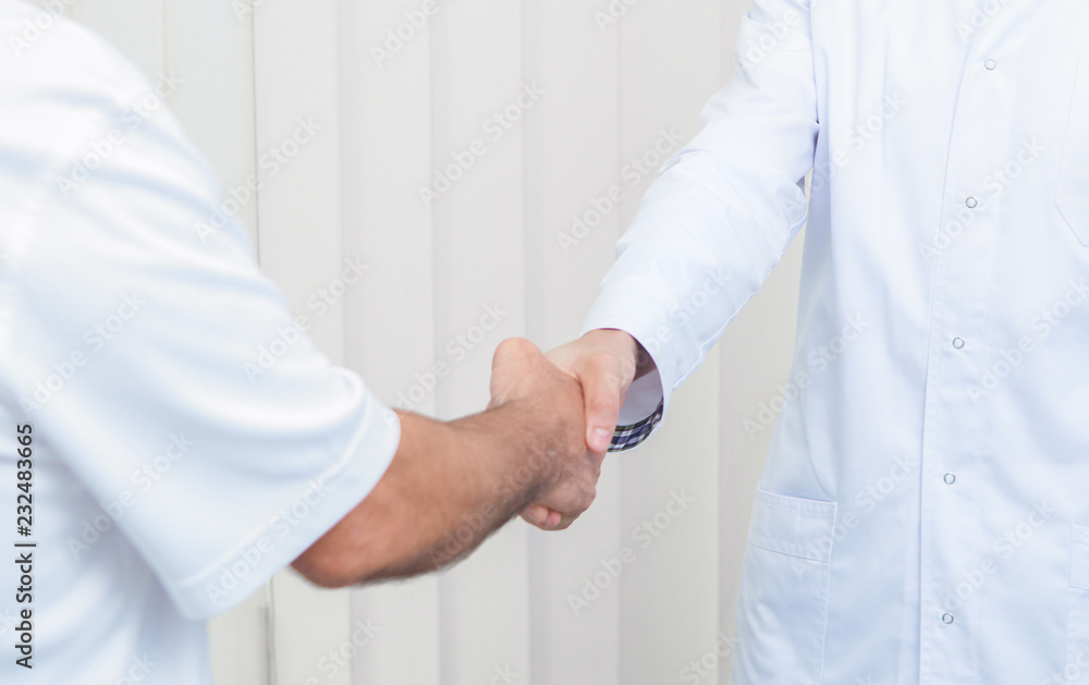 Close up of two doctors greeting each other at office. Close up of two doctors greeting each other at office.