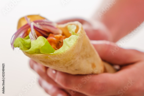 Mexican burrito in hand with chicken, pepper and beans photo