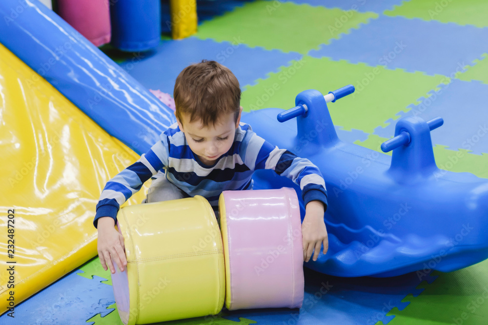 Kids climbing and sliding on outdoor playground. Children play in indoor playground. Amusement center in kindergarten or school yard. Child on colorful slide. Toddler kid. Kids climbing and sliding on outdoor playground. Children play in indoor playground. Amusement center in kindergarten or school yard. Child on colorful slide. Toddler kid.