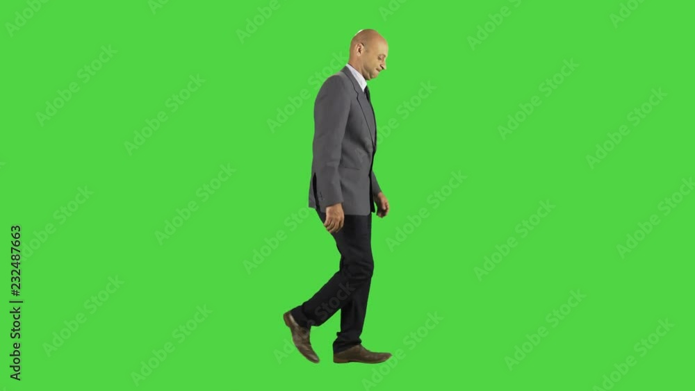 A businessman walks depressed, wearing a suit. full side shot over a green screen. A businessman walks depressed, wearing a suit. full side shot over a green screen.