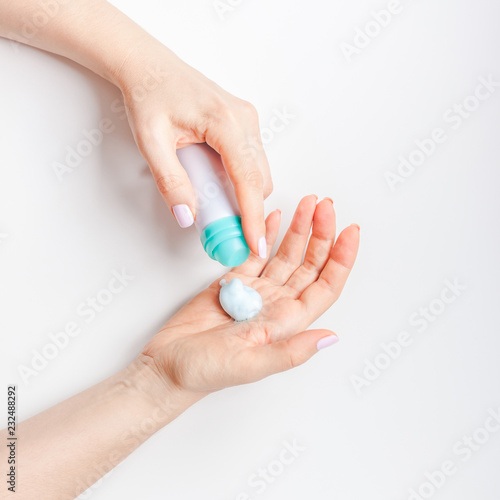 Woman moisturizing her hands with foam lotion