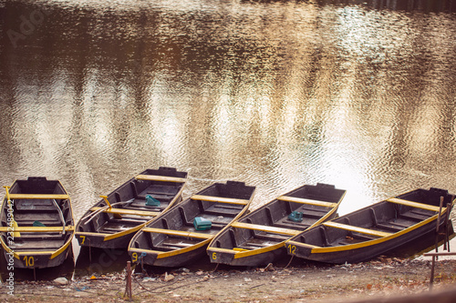 fishing boat in a calm lake water/old wooden fishing boat/ wooden fishing boat in a still lake water photo