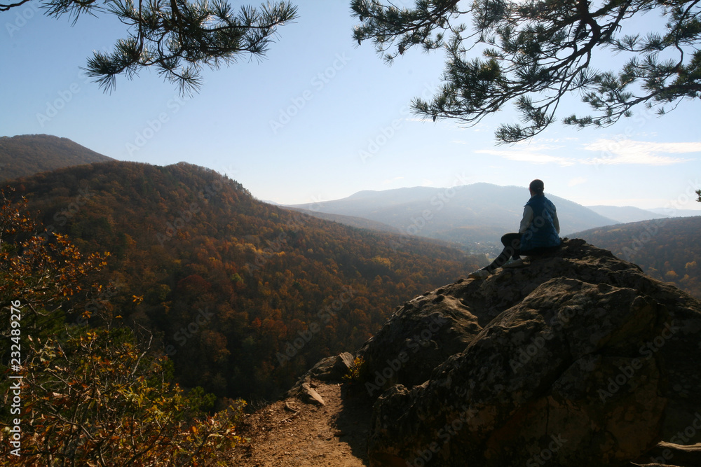 A young woman admires the view from the top of the Plancheskie rocks. A young woman admires the view from the top of the Plancheskie rocks.