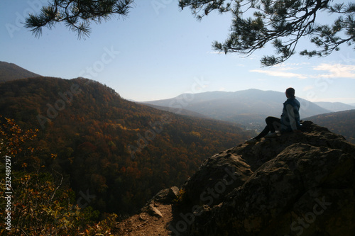 A young woman admires the view from the top of the Plancheskie rocks.