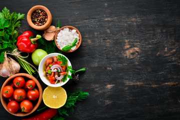 salsa sauce and ingredients. Latin American Mexican Traditional Sauce. Top view. On a black background. Free space for text.