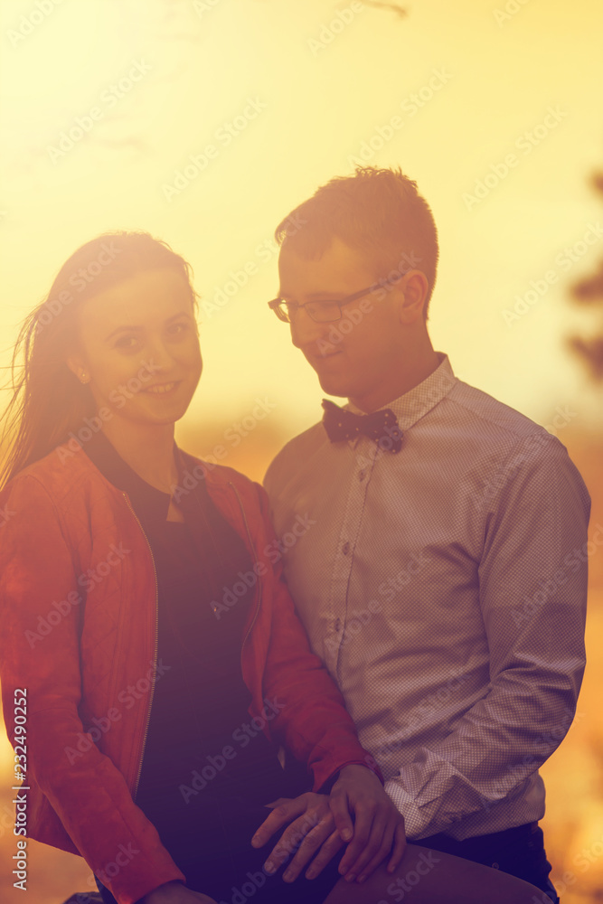 Portrait of happy young couple in love on blurred nature background in autumn. Vintage tone