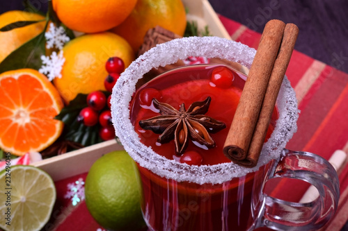 Hot mulled wine with slices of citrus fruits, cinnamon and anise in an Irish glass decorated with sugar border