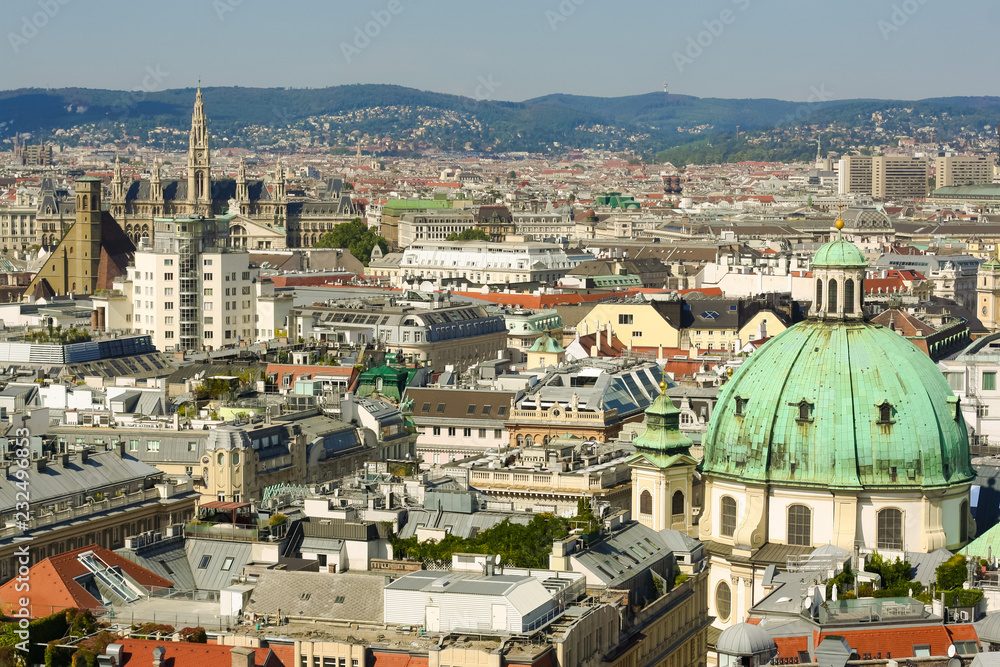 Vienna, Austria, September 09,2018:  Aerial view of Vienna with tower of the town hall building, votivkirche and peterskirche churches from the stephansdom cathedral.