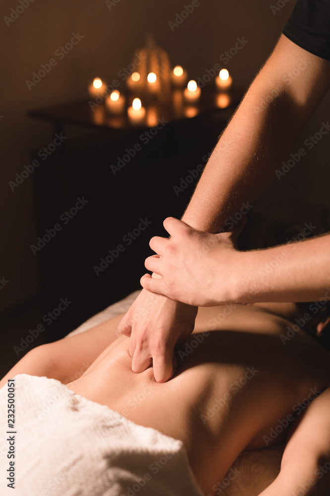 Obraz premium Close-up of male hands. Masseur does massage for the waist of a young girl. Rehabilitation, beauty therapy medicine. healthy concept