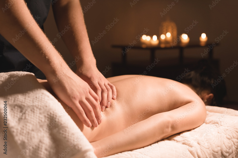 Fototapeta premium Close-up of male hands. Masseur does massage for the waist of a young girl. Rehabilitation, beauty therapy medicine. healthy concept