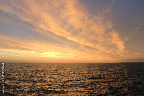 Sky Nature View of Sunset Over Calm Sea Water with Vibrant Orange Cloudscape. Beautiful Sky Background at Sunset or Sunrise  Dusk and Dawn Panoramic Skyline View with Still Water on Summer Season Day