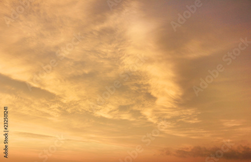 Sunset Sky Background with Soft Yellow Sky Color. Scenic Sky Cloudscape at Sunset or Sunrise, Dusk and Dawn Outdoor Nature Wallpaper. Beautiful Warm Sunlight View at Evening Sunset Scene through Cloud © onajourney