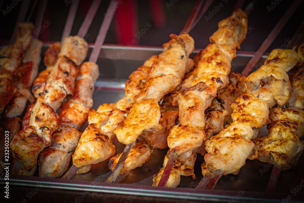 Fresh kebabs on skewers, selective focus. Grill on charcoal and flame, picnic, street food. Background with vignette