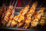 Fresh kebabs on skewers, selective focus. Grill on charcoal and flame, picnic, street food. Background with vignette
