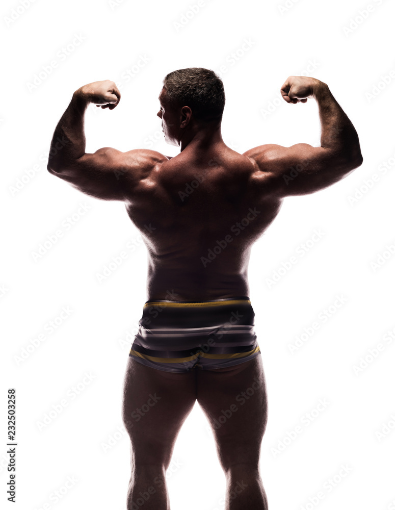 powerful man shows off his biceps and back in Studio shirtless on white background powerful man shows off his biceps and back in Studio shirtless on white background