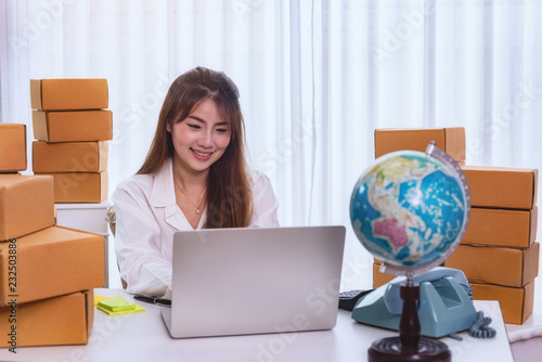 Young Women happy after new order from customer, business owner working at home office packaging on background. online shopping SME entrepreneur or freelance working concept.