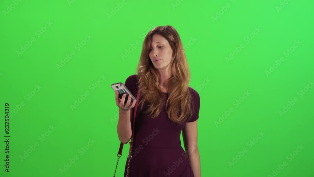 Young woman walking in a medium frontal shot over a green screen, filtering a call from a blocked number, casual look. Young woman walking in a medium frontal shot over a green screen, filtering a call from a blocked number, casual look.