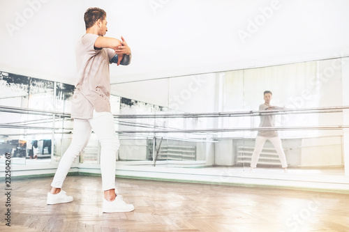 Young teen dancer exercise the dance element in front of the mirror portrait in the hall