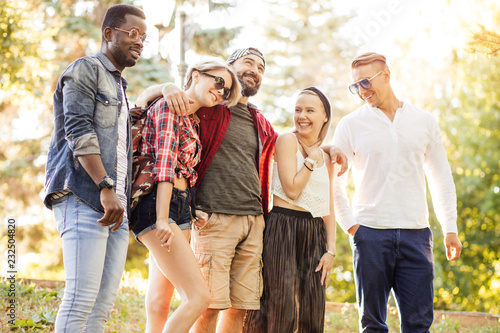 Diverse group of young adult people in cassual summer outfit gathering in summer park after their outdoor workout photo