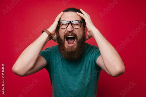 Photography screaming bearded brutal man and looking at the camera with hands up goal winner