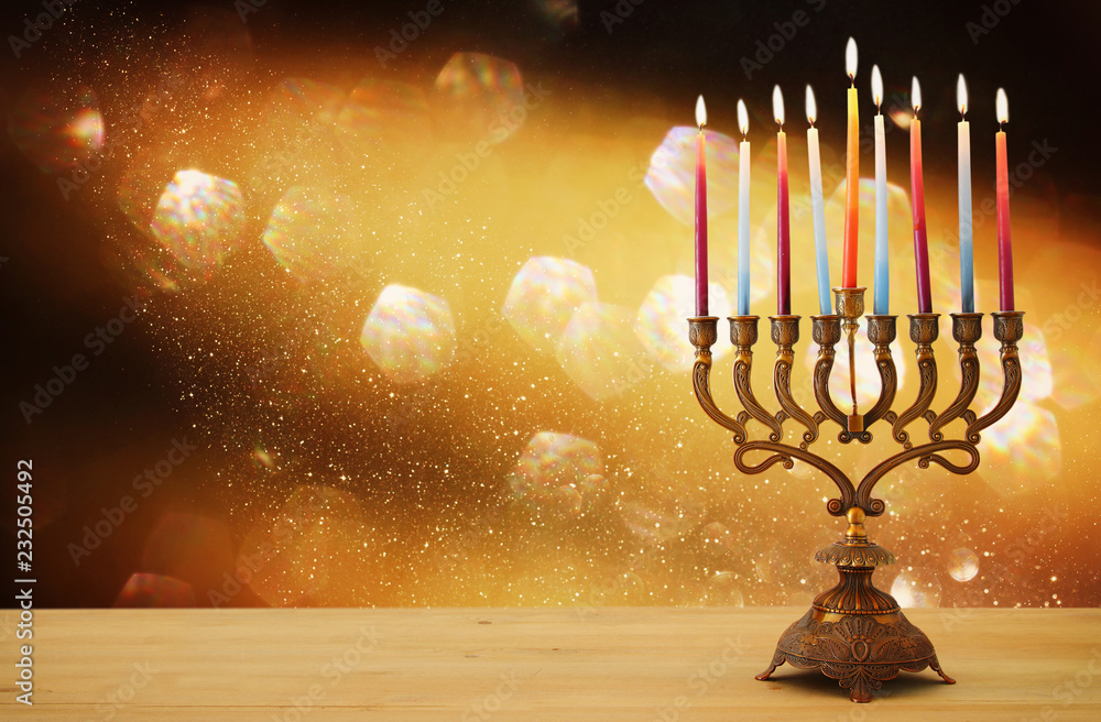 image of jewish holiday Hanukkah background with menorah (traditional candelabra) and candles over glitter shiny background. image of jewish holiday Hanukkah background with menorah (traditional candelabra) and candles over glitter shiny background.