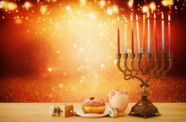 image of jewish holiday Hanukkah background with menorah (traditional candelabra) and candles over glitter shiny background.