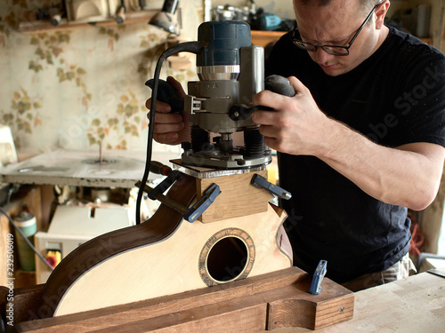 luthier carves a sundport in a guitar.