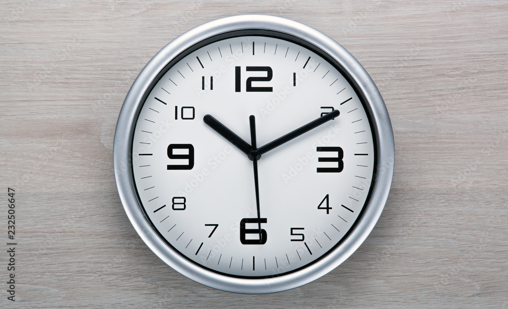 white clock face with black digits on a wooden gray background white clock face with black digits on a wooden gray background