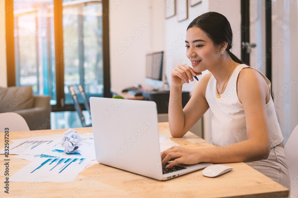business woman looking at laptop and documents during working day in office. business woman looking at laptop and documents during working day in office.