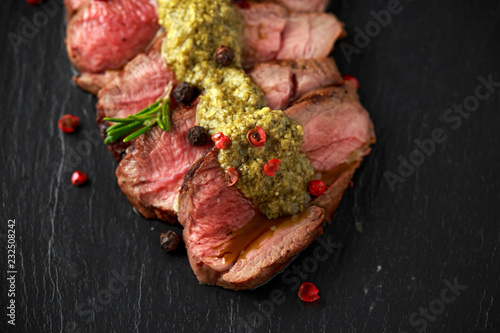 Obraz na plátně Medium rare venison steak with green pesto sauce and pepper