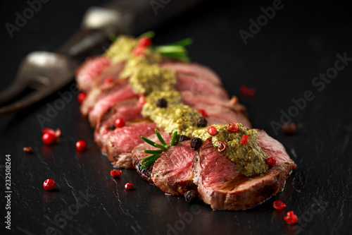 Billede på lærred Medium rare venison steak with green pesto sauce and pepper
