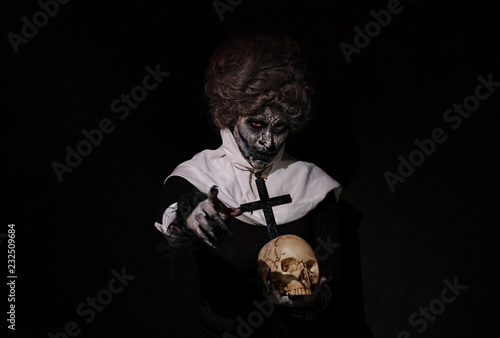 фотографія Woman Halloween theme nun holding Skull
