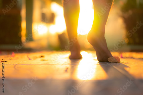 Blur barefoot man walking on the floor with sunrise light shine