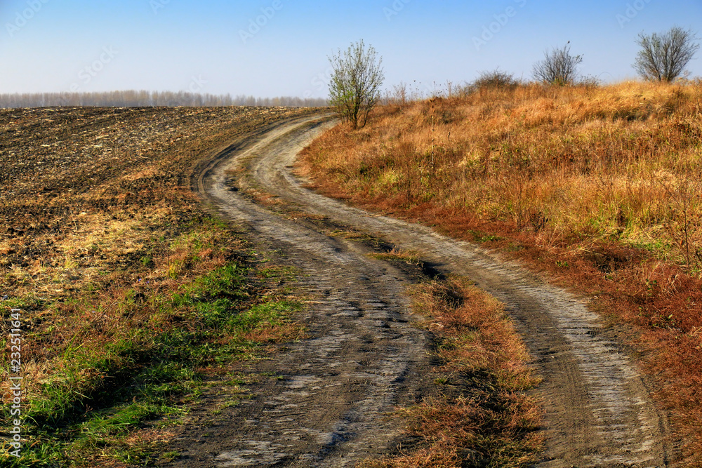 Beautiful Fall scene on curved unpaved road Beautiful Fall scene on curved unpaved road