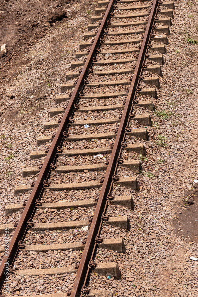 A close up view of a straight metal and concrete railway lines