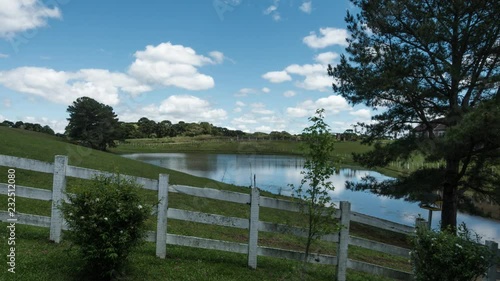sunny day cloud moving above fencing and vast pond in giantic back yard