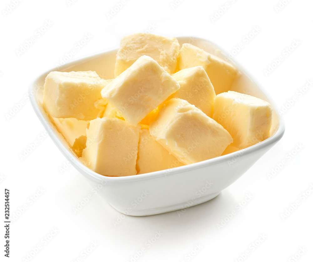 Butter cubes in white bowl isolated on white background Butter cubes in white bowl isolated on white background