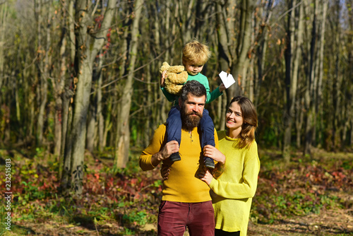 Family group of father, mother and child on walk outdoor. Group of people smile in spring park. Enjoy a healthy dose of nature