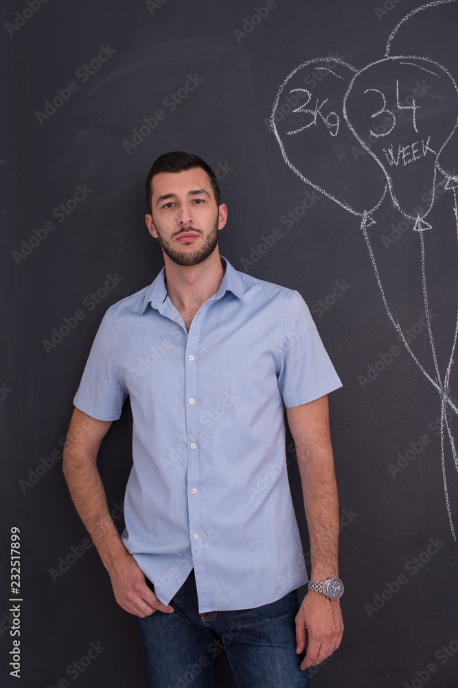 portrait of man in front of black chalkboard
