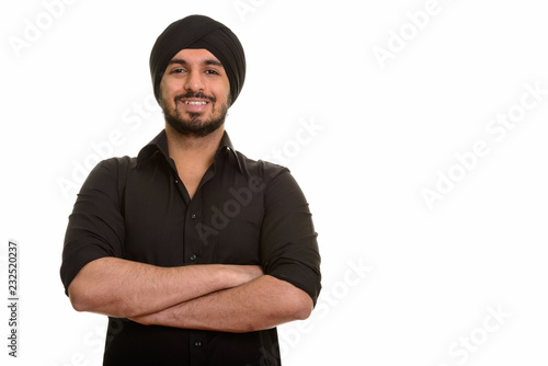 Portrait of young happy Indian Sikh man smiling photo